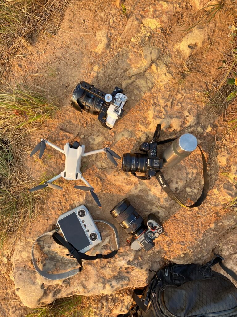 Equipo fotográfico compuesto por cámaras Sony, Canon, Nikon y un drone DJI al amanecer.